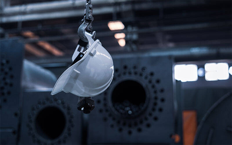 Photo intérieure d'une usine avec un casque de chantier blanc accroché