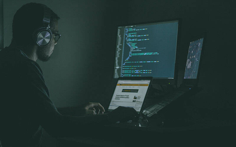 Programmeur travaillant sur un code dans une pièce sombre