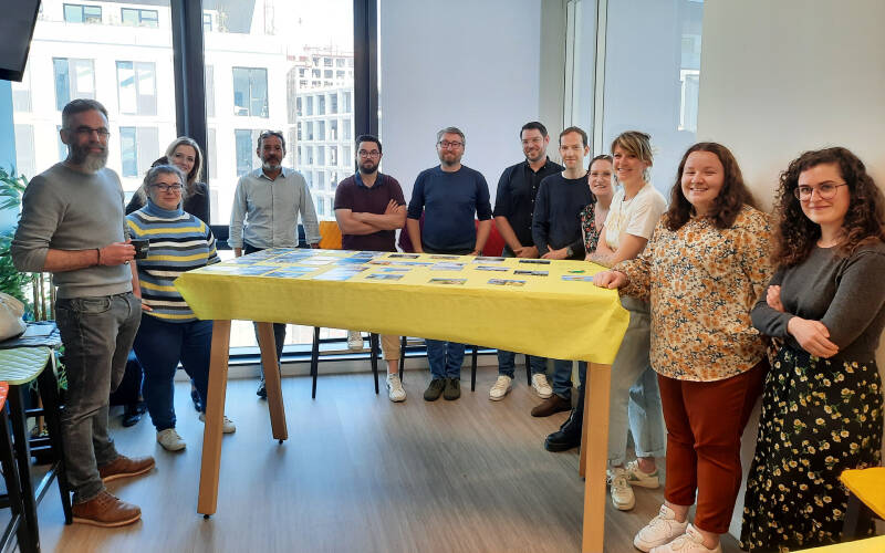 Des hommes et des femmes réunis autour d'une table avec la fresque numérique