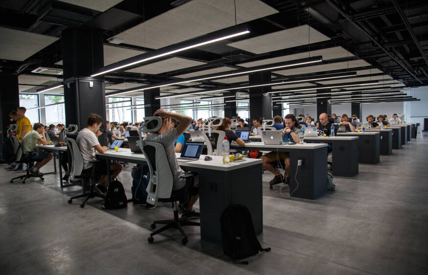 Un grand open space avec des bureaux et des personnes en train de travailler