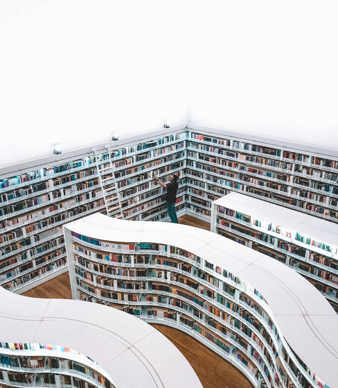 une bibliothèque moderne de couleur blanche avec une personne devant une des étagères