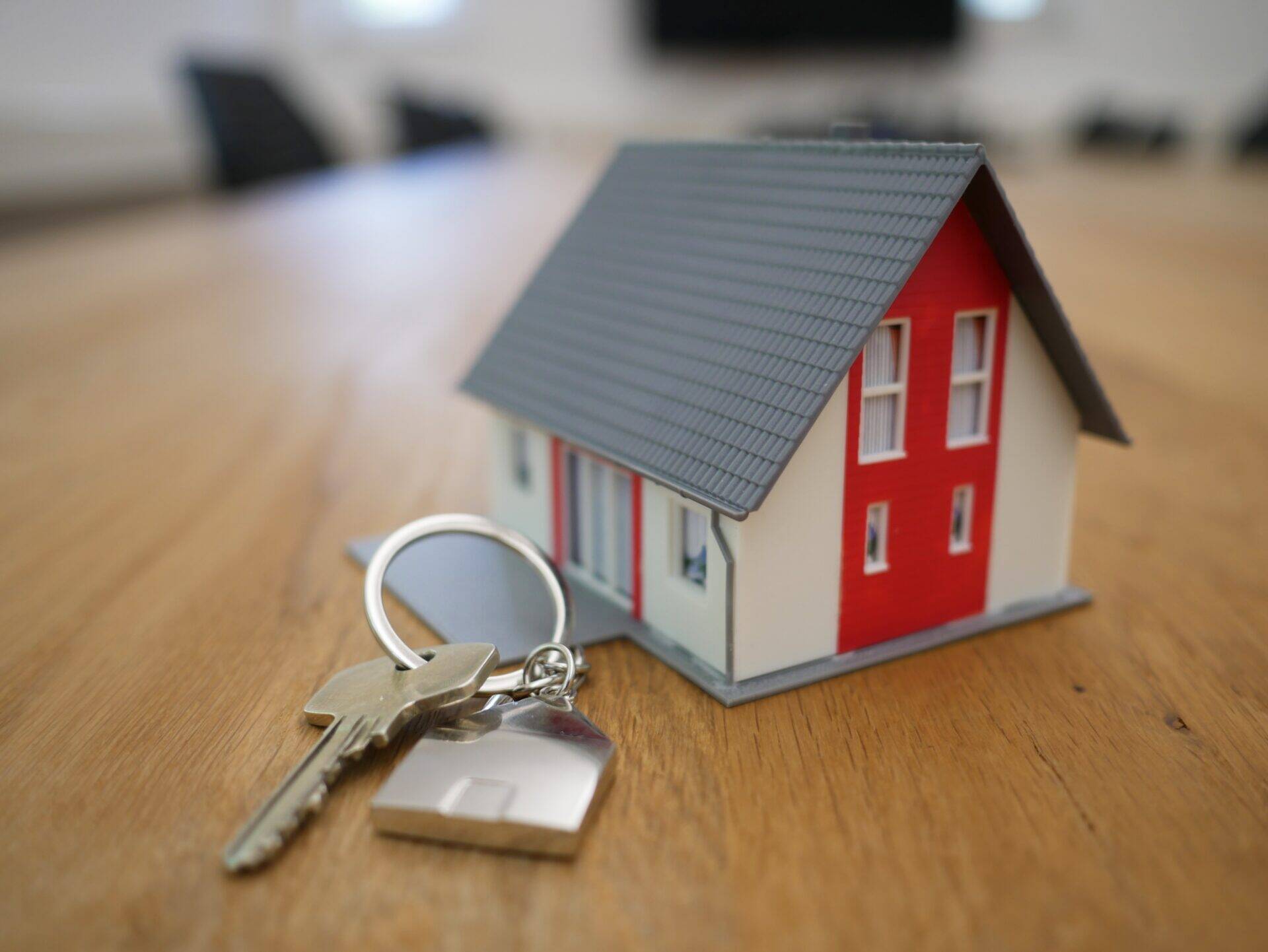 clé de maison à côté d'une maison miniature