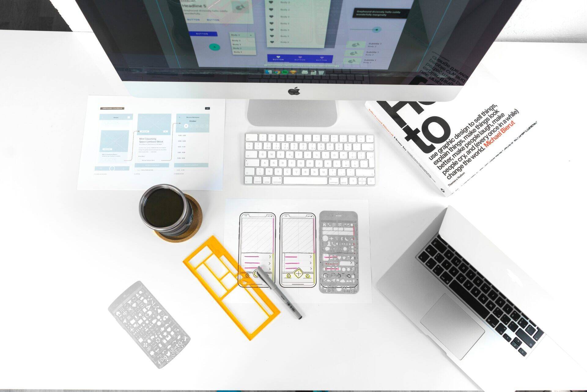 Bureau vu du dessus, avec un écran, clavier, ordinateur portable, tasse...