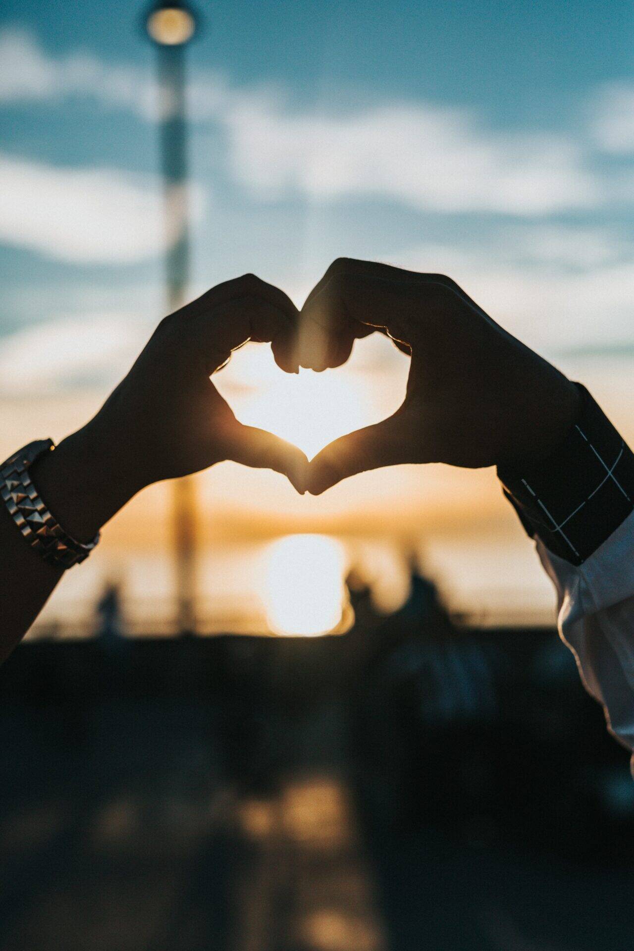 main qui forme un coeur face à un coucher de soleil mission handicap