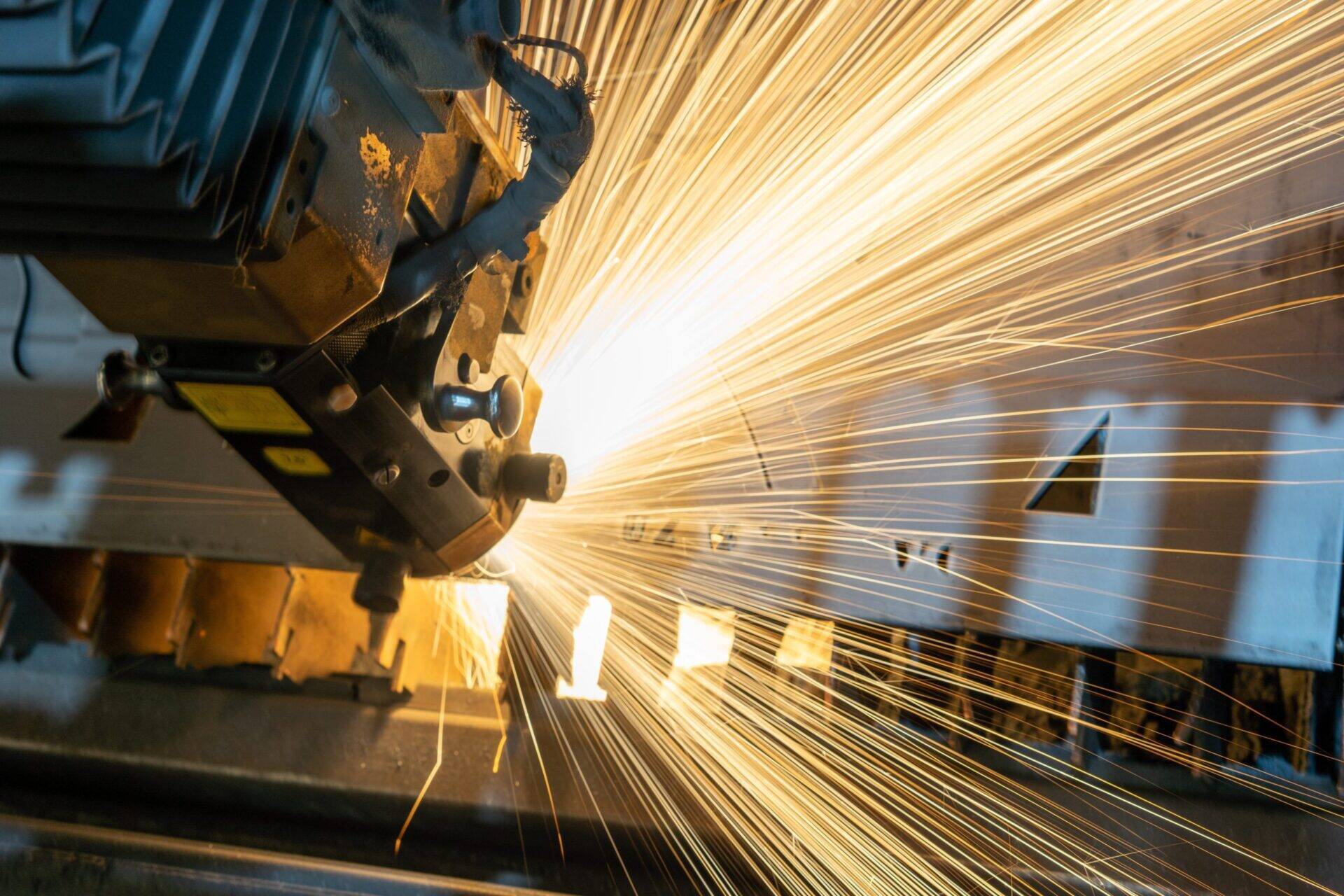 Une machine industrielle en train de fonctionner provoquant des étincelles sur une pièce métallique