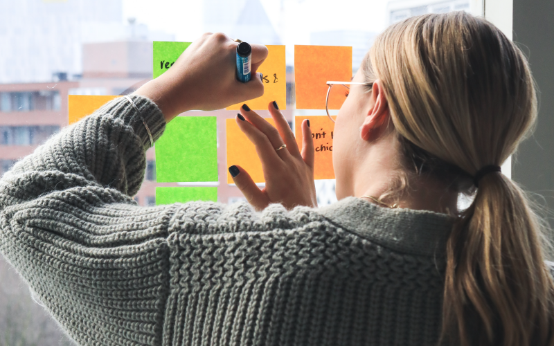 Une femme brainstorming besoin avec post-it