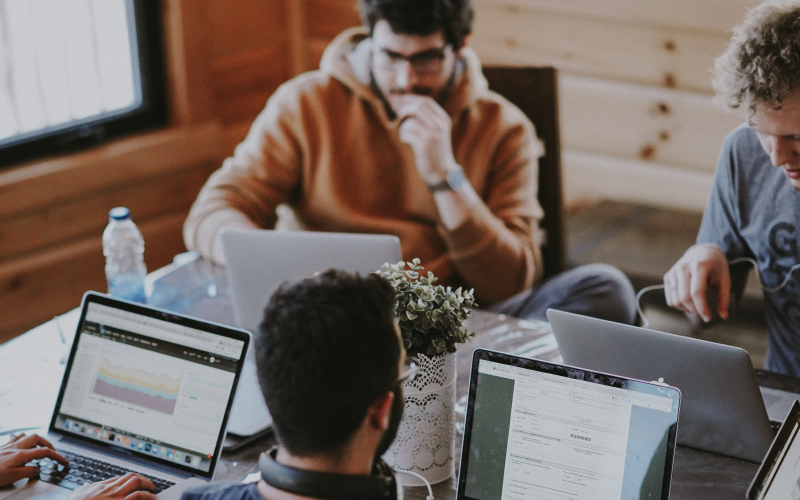 4 personnes autour d'une table avec leurs ordinateurs